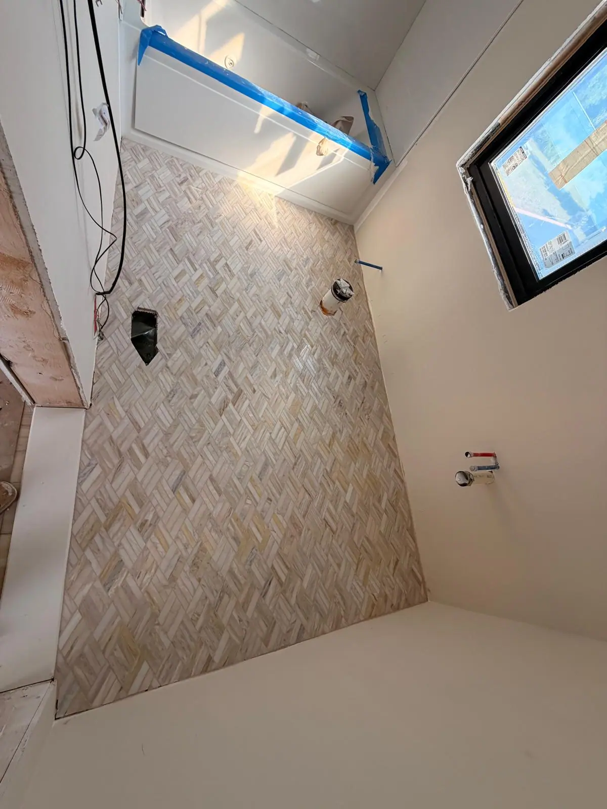 Herringbone floor tile being installed in a bathroom