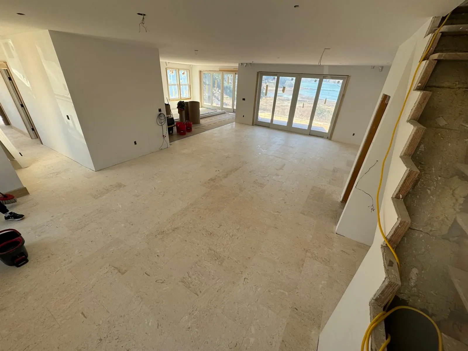 Light large-format tile floor across an open room with windows