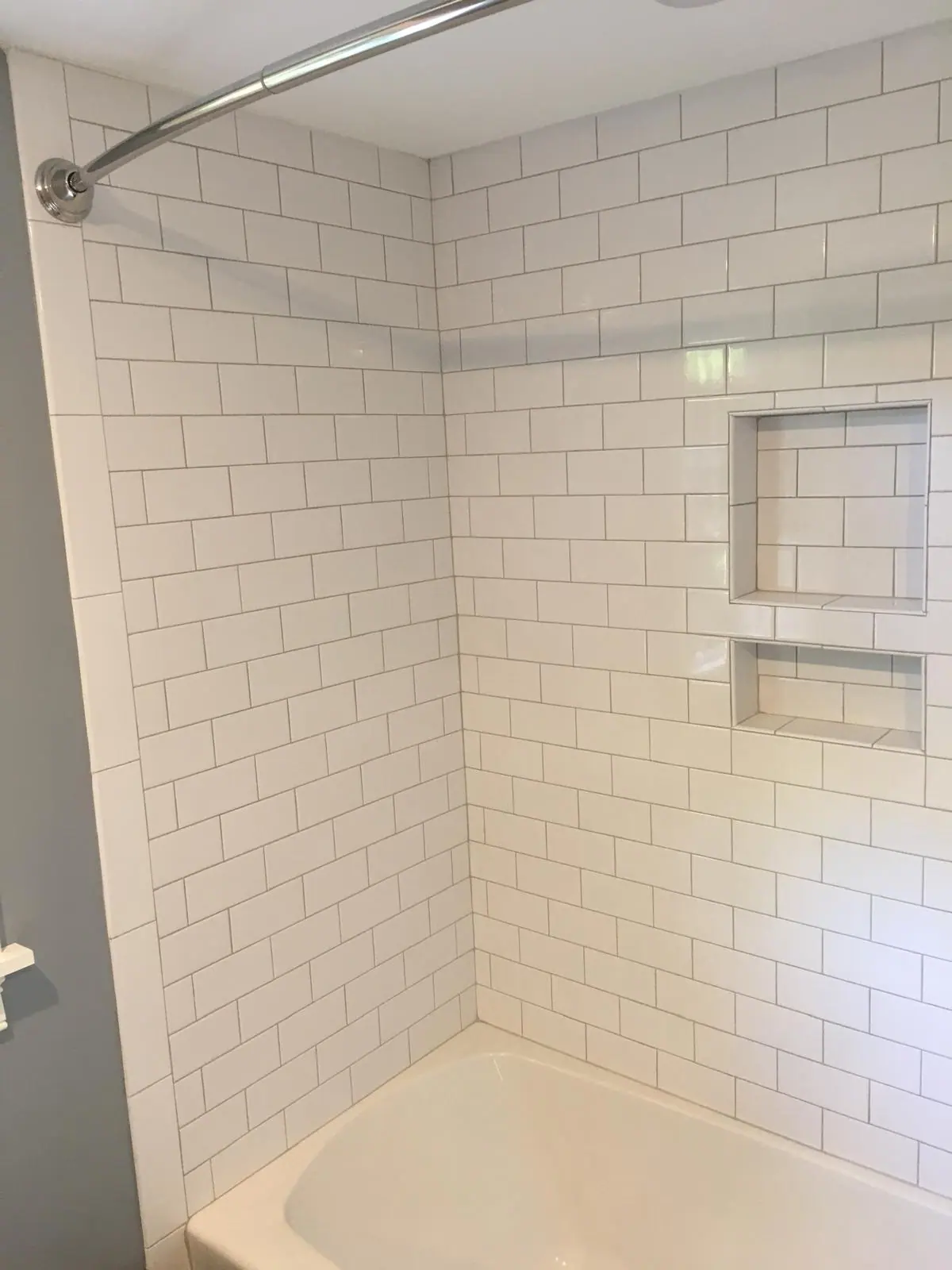 White subway tile wall with a stacked double niche